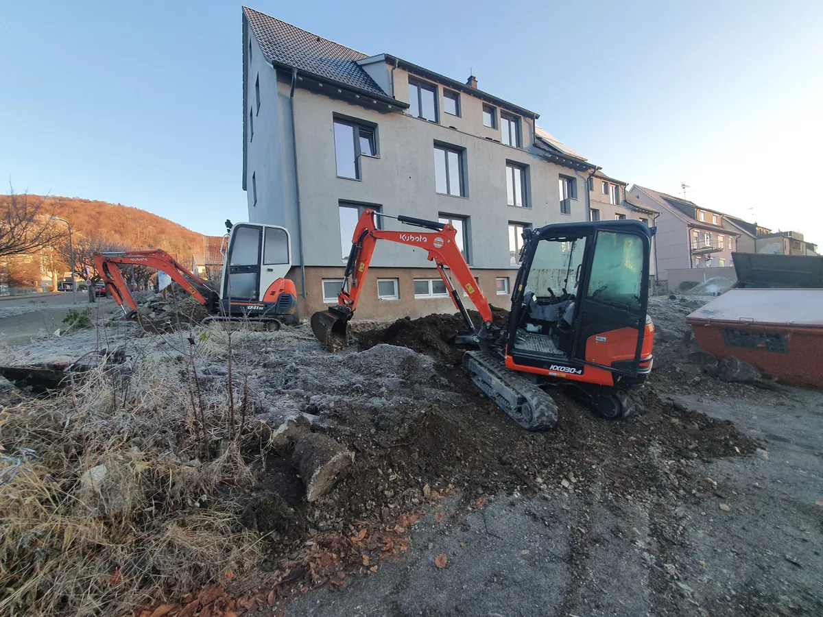 Minibagger der Topal GmbH hebt die Baugrube vor einem Mehrfamilienhaus aus