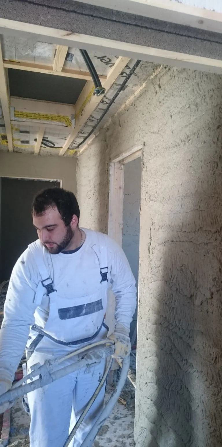 Mitarbeiter der Topal GmbH trägt Kalkzementputz in einem Altbau auf